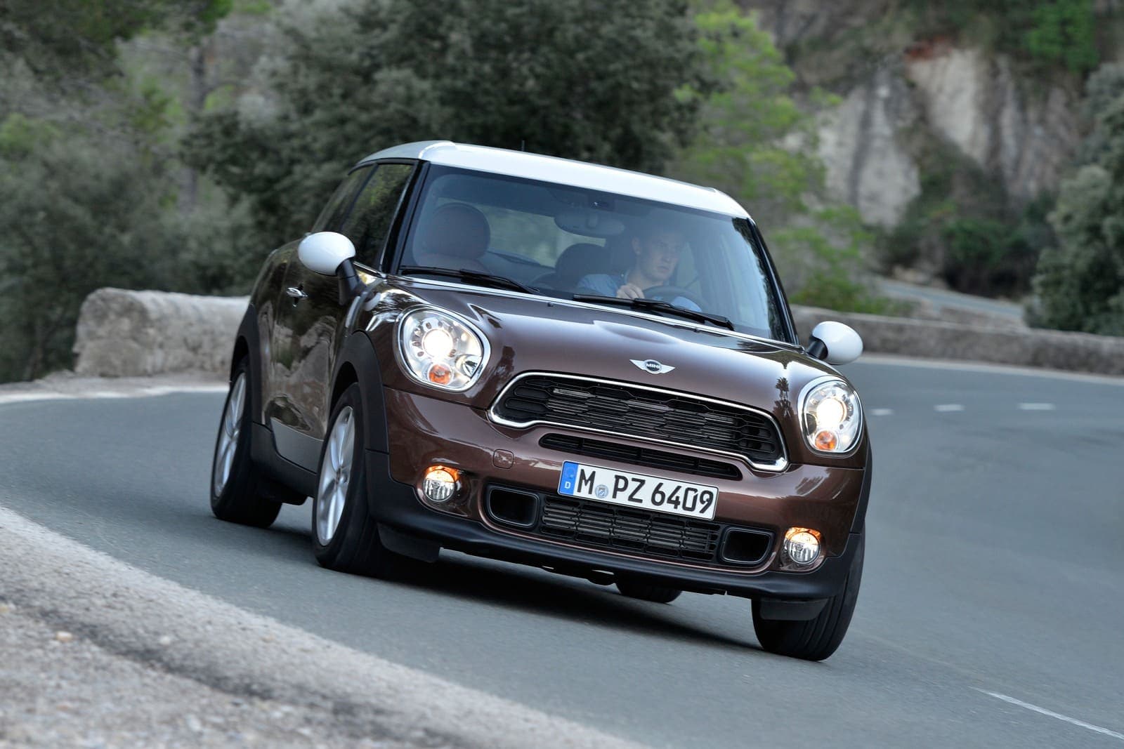 Klasyczny MINI Paceman Cooper S w widoku od przodu na górskiej drodze, brązowe nadwozie z białym dachem