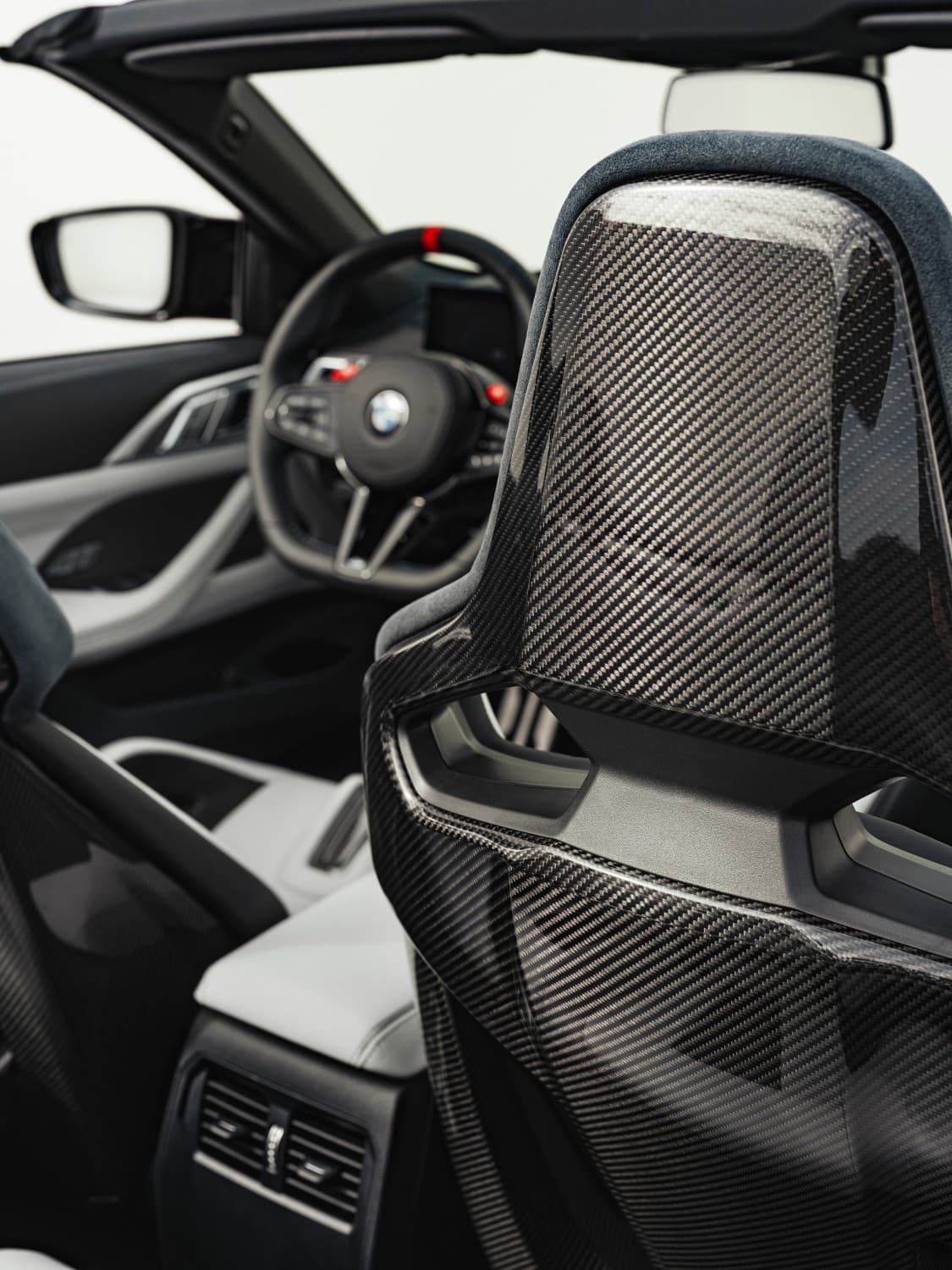 auto_bmw_nowe-samochody_bmw-m4-cabrio_ac9dea9a Zagłówek fotela pasażera. Widok z tylnej kanapy